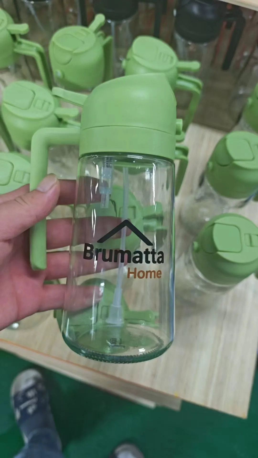 Finished custom-colour glass oil bottle with client logo, fresh off the production line